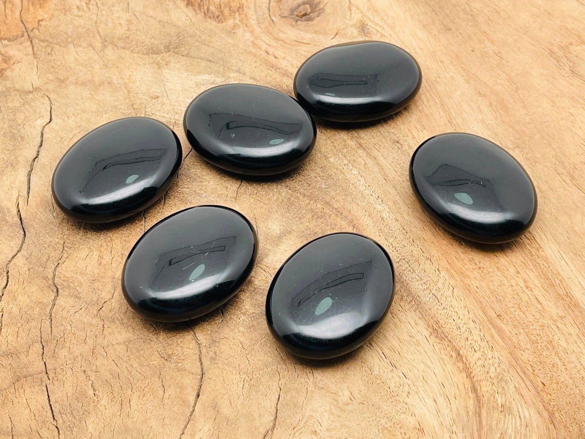 Obsidian palm gemstone spa stone measuring 45x35mm from GemstoneGO, smooth black volcanic stone for relaxation and massage.
