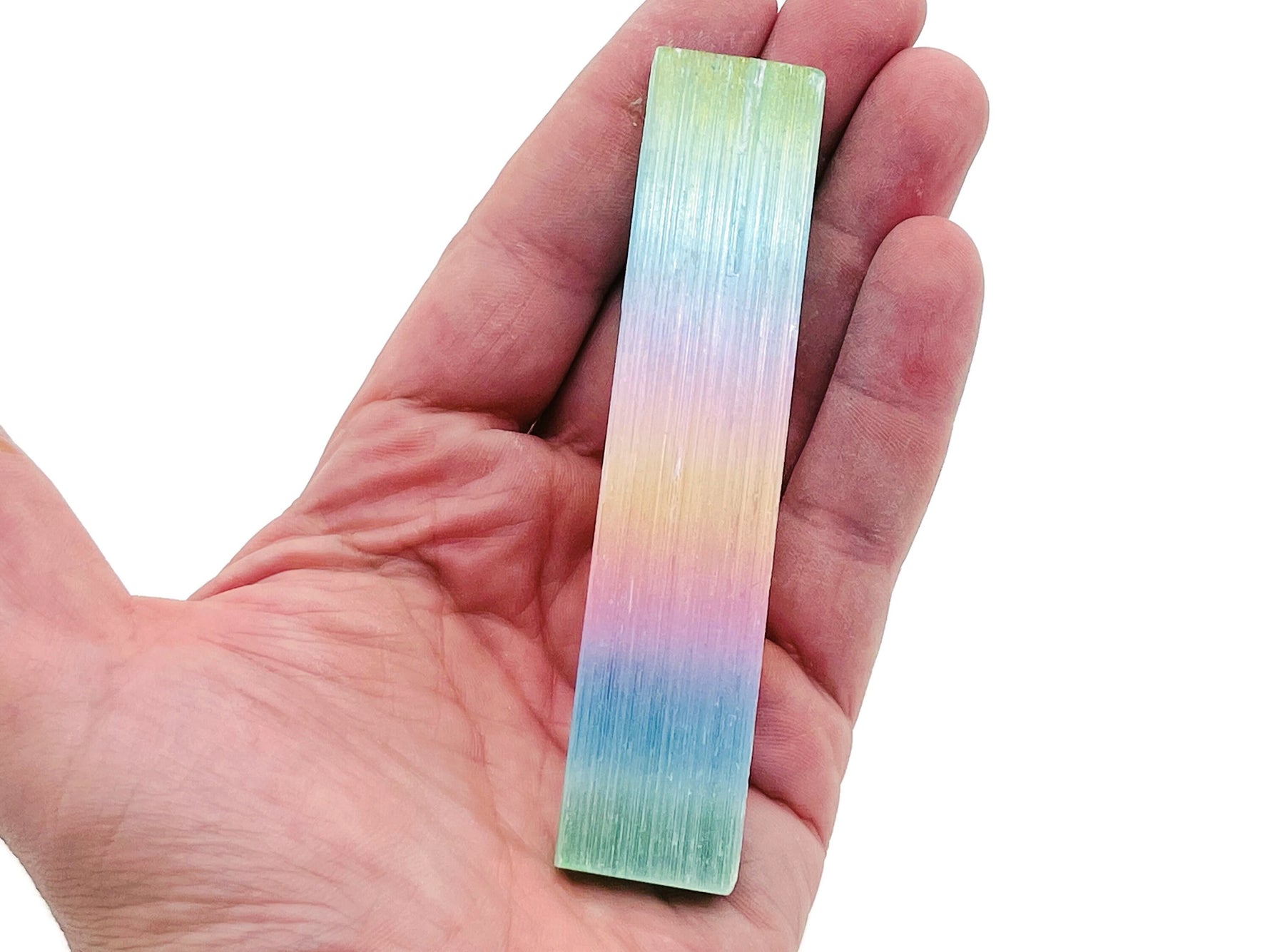 Rainbow Aura Selenite Wand gemstone in various sizes, showcasing its vibrant, iridescent colors and raw crystal texture.