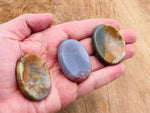 Moss agate worry stone from GemstoneGO, 4.5x3.5cm, featuring natural green and brown patterns, smooth polished crystal for soothing use.