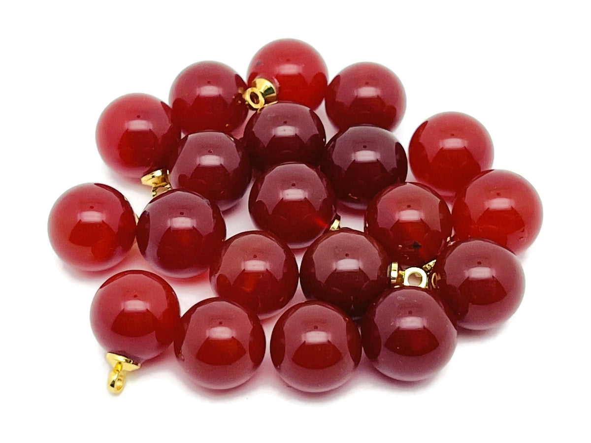 Carnelian ball beads with a crystal pendant, showcasing vibrant orange gemstone jewelry from GemstoneGO.