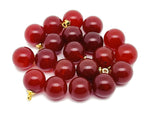 Carnelian ball beads with a crystal pendant, showcasing vibrant orange gemstone jewelry from GemstoneGO.