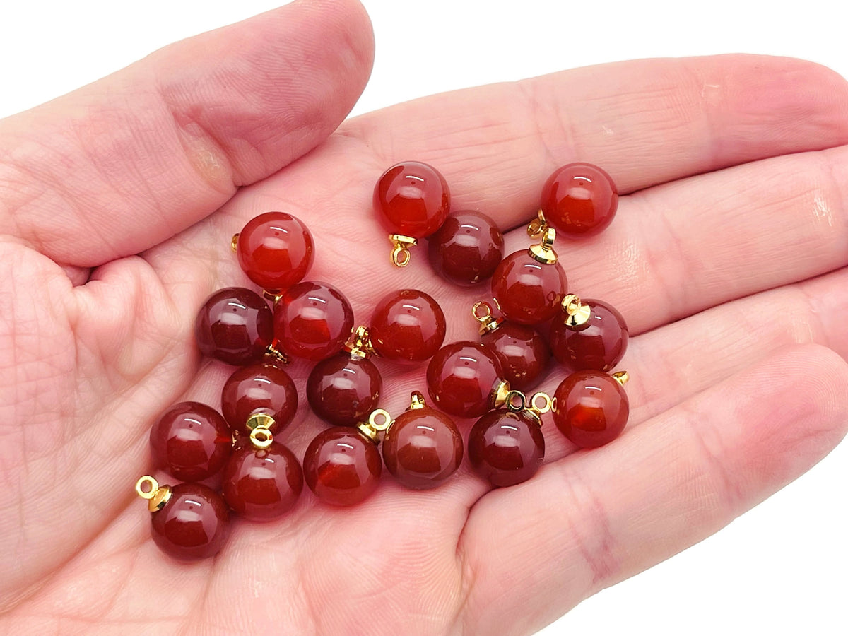 Carnelian ball beads with crystal pendant, showcasing vibrant orange stones and jewelry design from GemstoneGO.