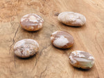 Flower Agate palm gemstone spa stone with cherry blossom pattern, showcasing vibrant colors and intricate natural mineral details.