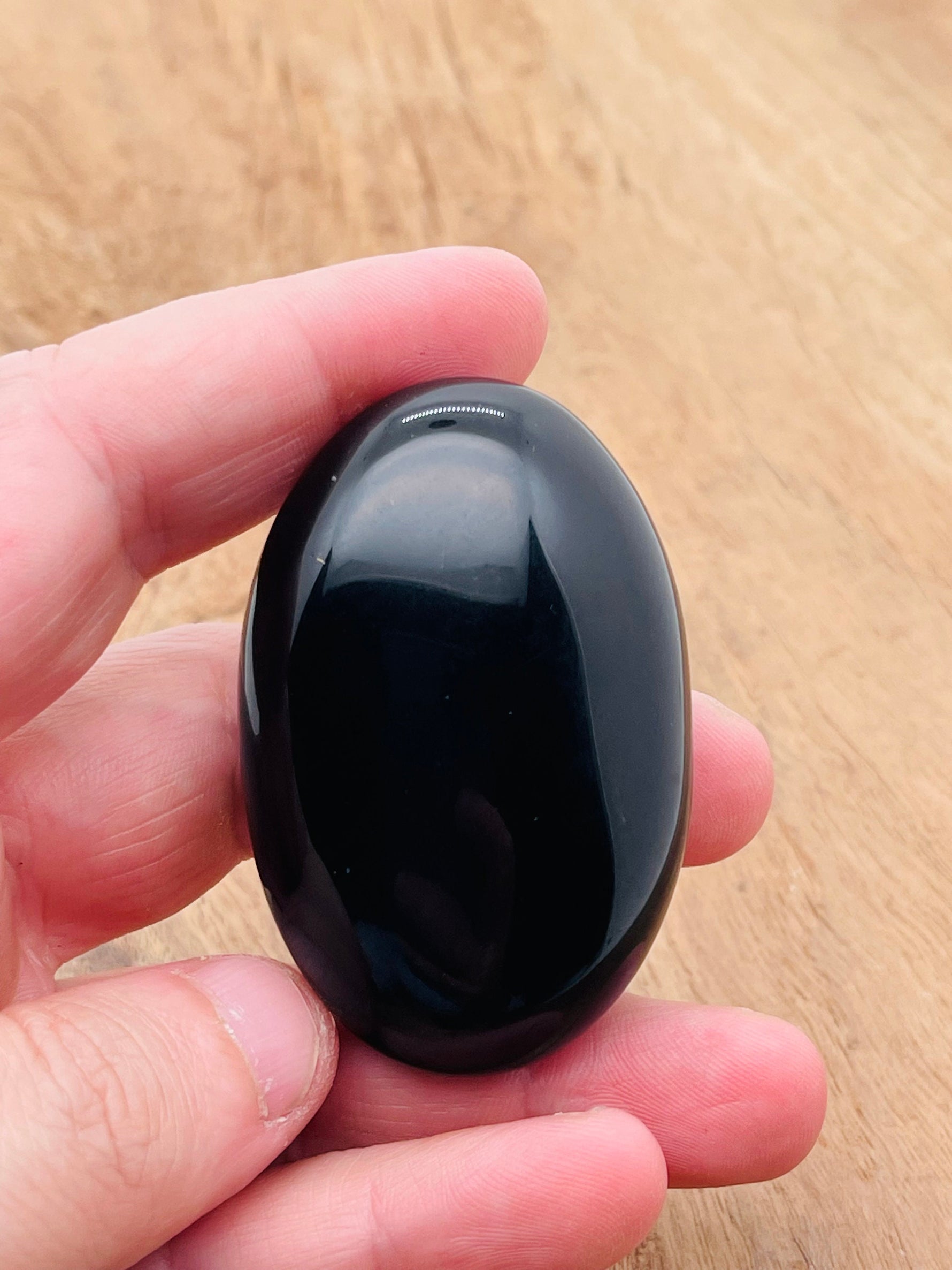 Obsidian palm gemstone spa stone, 60x40mm, from GemstoneGO, showing smooth, polished black volcanic stone for therapeutic use.