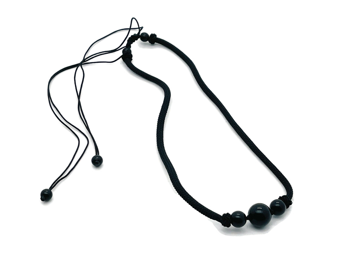 Obsidian sphere crystal pendant necklace with cord, featuring a polished black gemstone for healing and spiritual energy.
