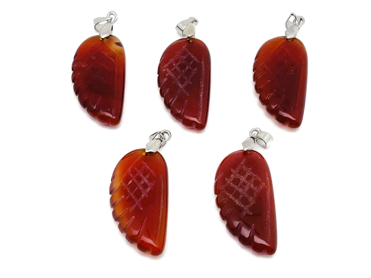 Carnelian angel wing crystal pendant with hole charm, featuring vibrant orange-red gemstone and silver-tone metal details.
