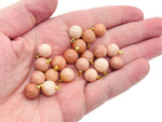 Orange aventurine ball beads with crystal pendant jewelry, showcasing vibrant orange gemstone and polished stone details.
