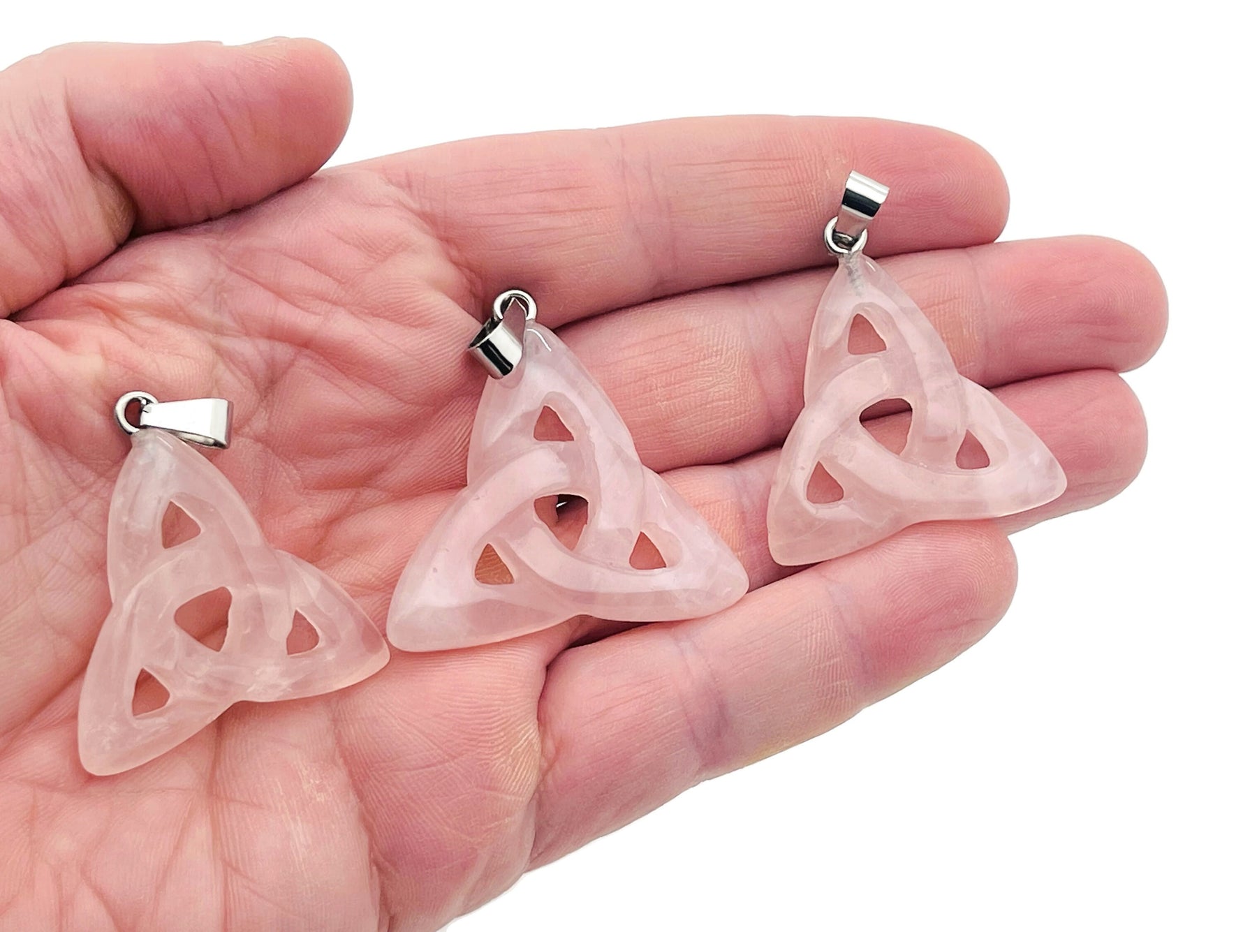 Rose quartz Celtic knot crystal pendant from GemstoneGO featuring a Trinity Crystals design on a silver chain.