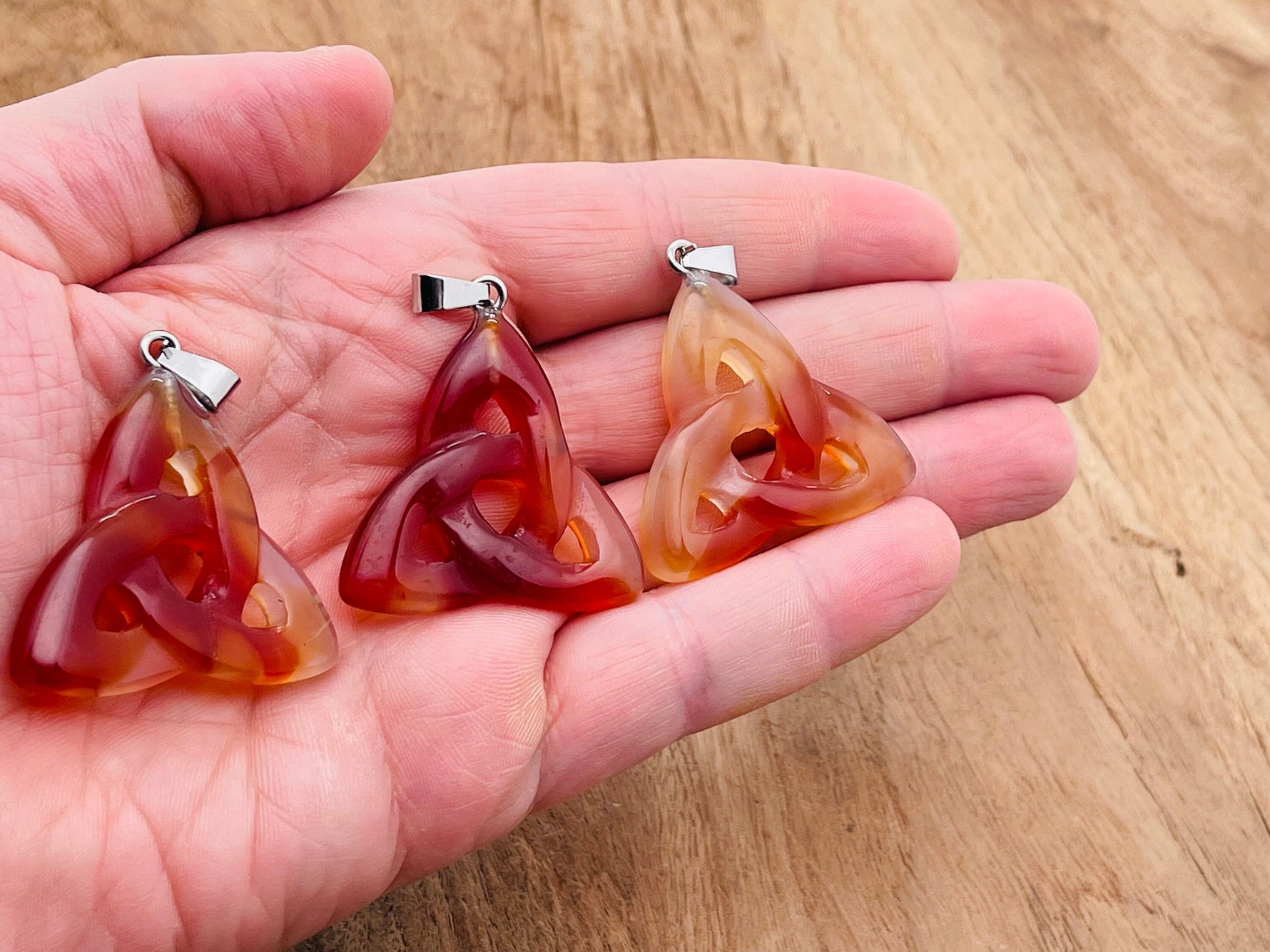 Carnelian Celtic knot crystal pendant from GemstoneGO featuring a Trinity Crystals design with intricate Celtic knot details.