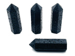 Lava volcanic obelisk tower crystal from GemstoneGO, featuring a black and orange textured volcanic stone sculpture.