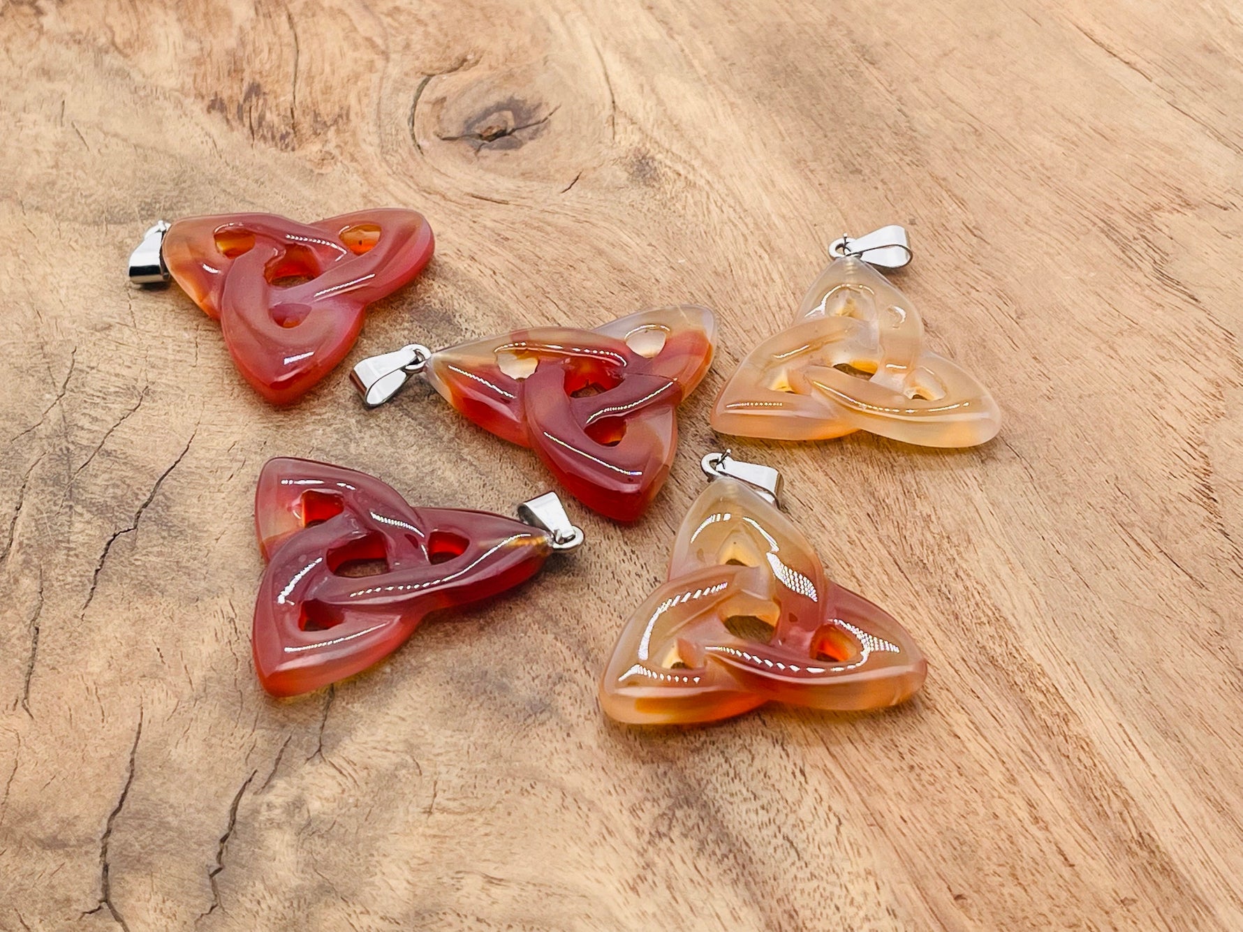 Carnelian Celtic knot crystal pendant by GemstoneGO featuring a Trinity Crystals design on a silver chain.