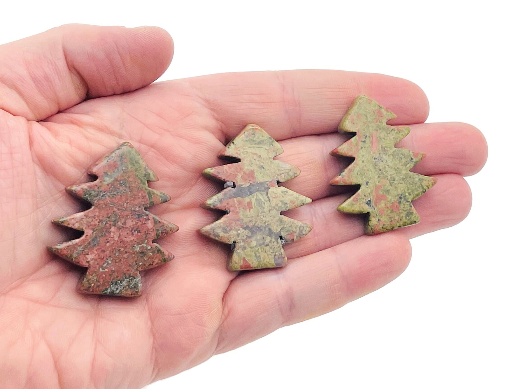 Handmade Unakite gemstone pine tree carving displaying vibrant green and pink hues, detailed tree shape on a clear background