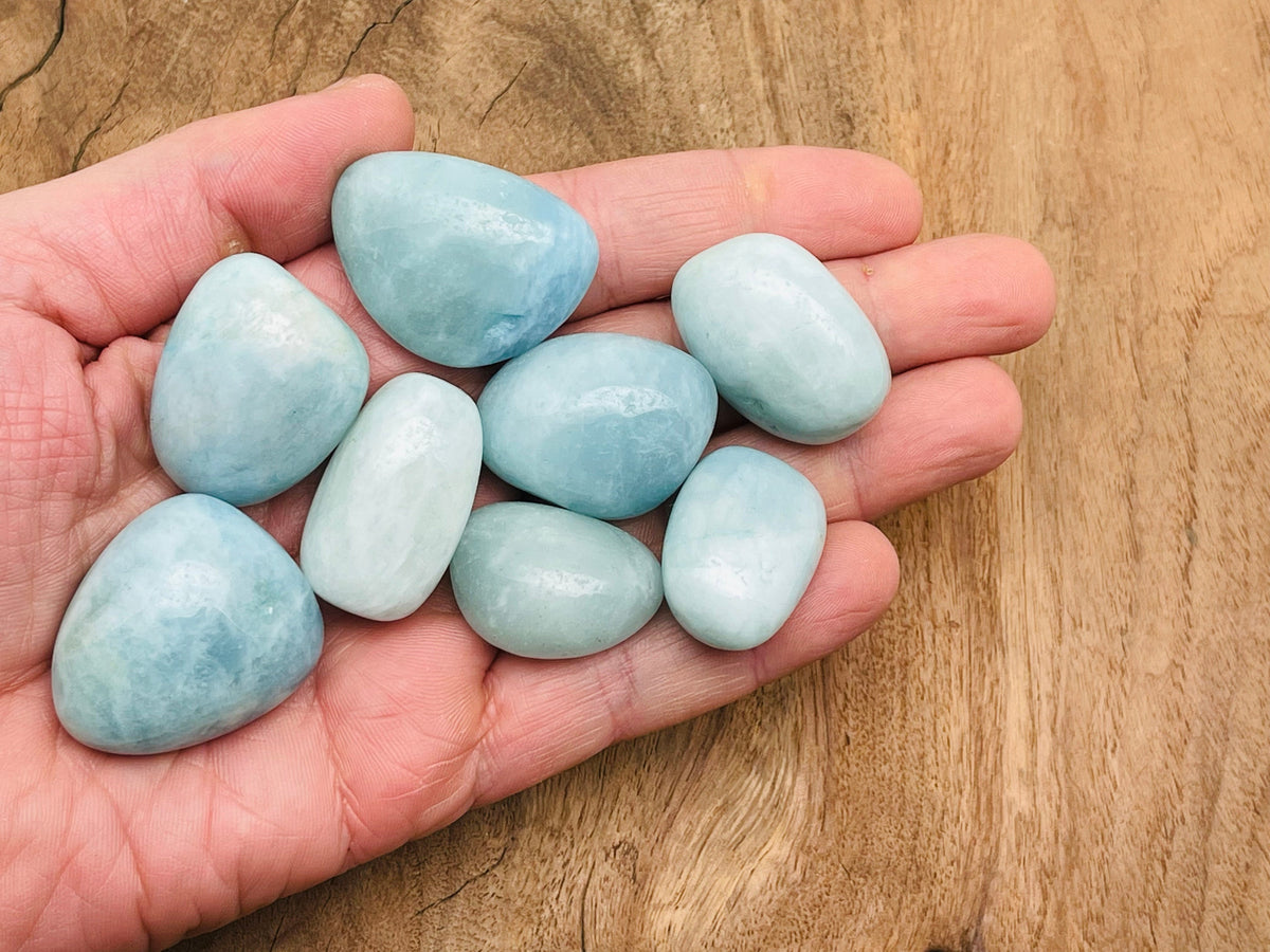 Smooth aquamarine tumbled stone from GemstoneGO, showcasing its light blue color and polished, rounded surface.