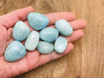 Smooth aquamarine tumbled stone from GemstoneGO, showcasing its light blue color and polished, rounded surface.