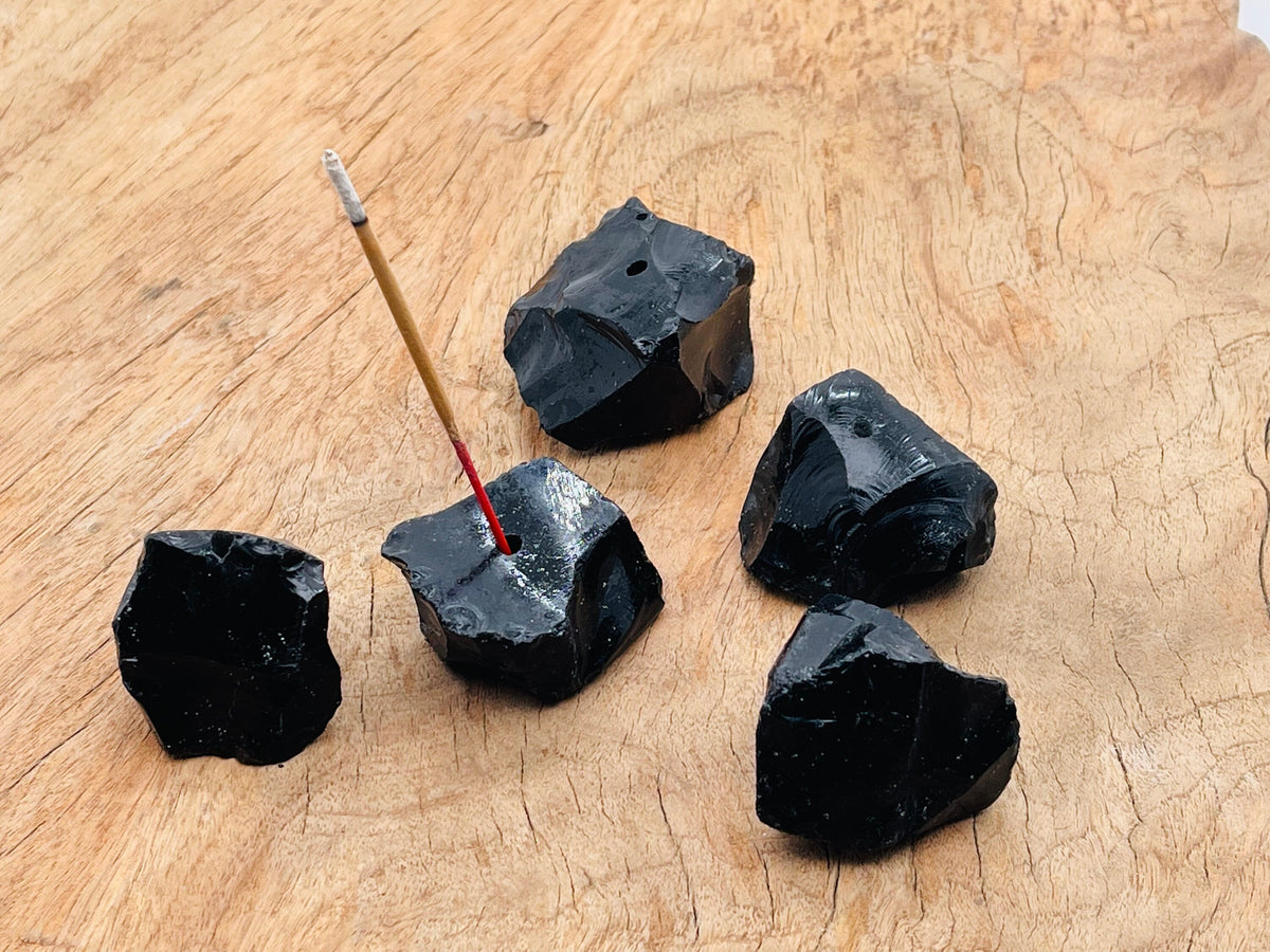 Handmade obsidian rough crystal incense holder with carved design for incense sticks, showcasing dark natural stone texture.