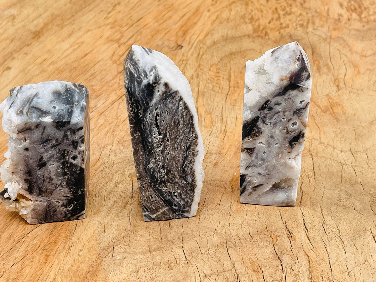 Sphalerite obelisk tower crystal from GemstoneGO showing a dark, polished mineral with natural striations and geometric shape.