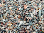 Close-up of semi-tumbled petrified wood crystal chips in 5-7mm size, showcasing natural wood grain patterns and earthy tones.