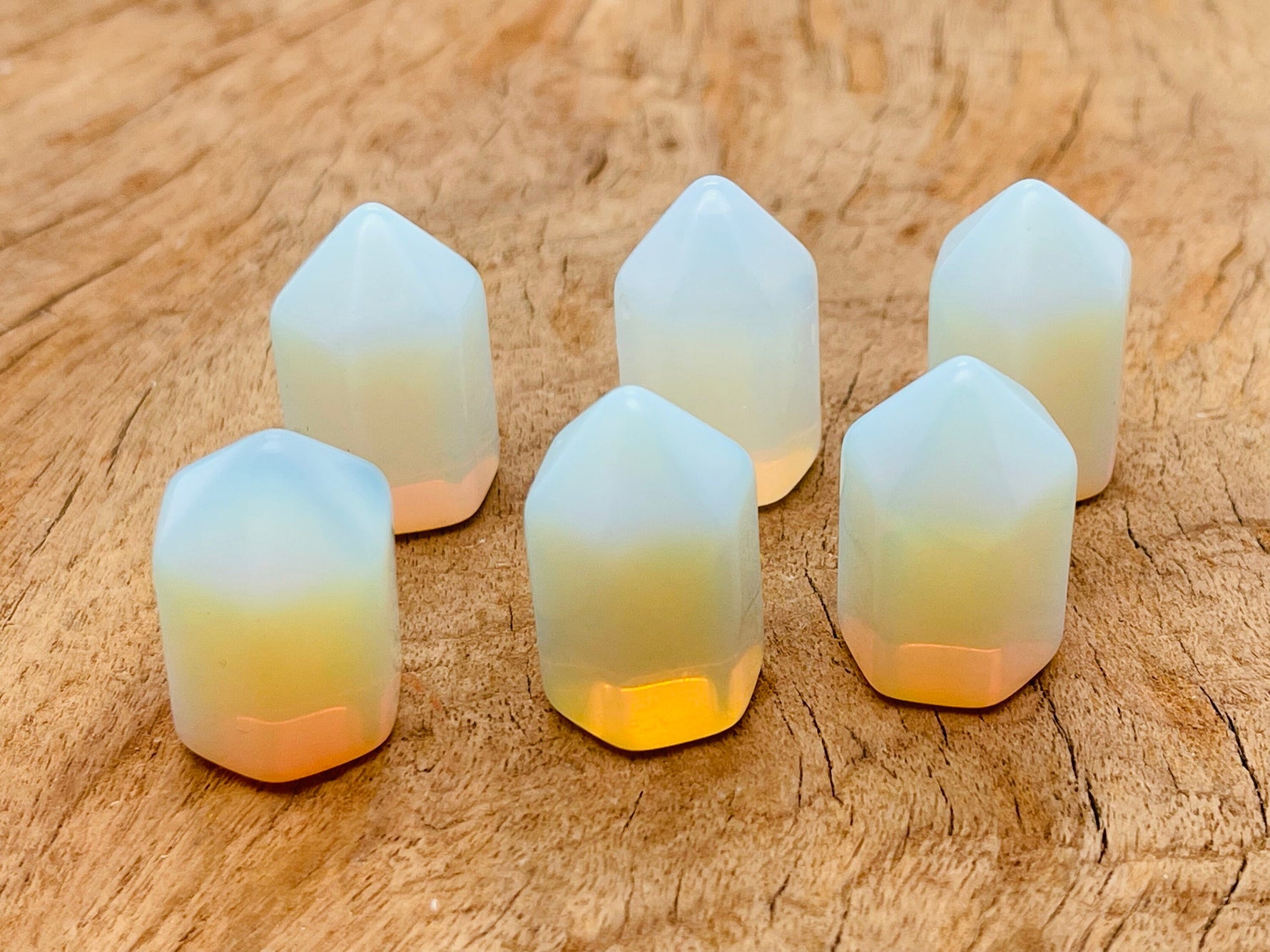 Opalite obelisk tower crystal from GemstoneGO, 25mm, showcasing smooth polished surface and translucent blue-white glow.