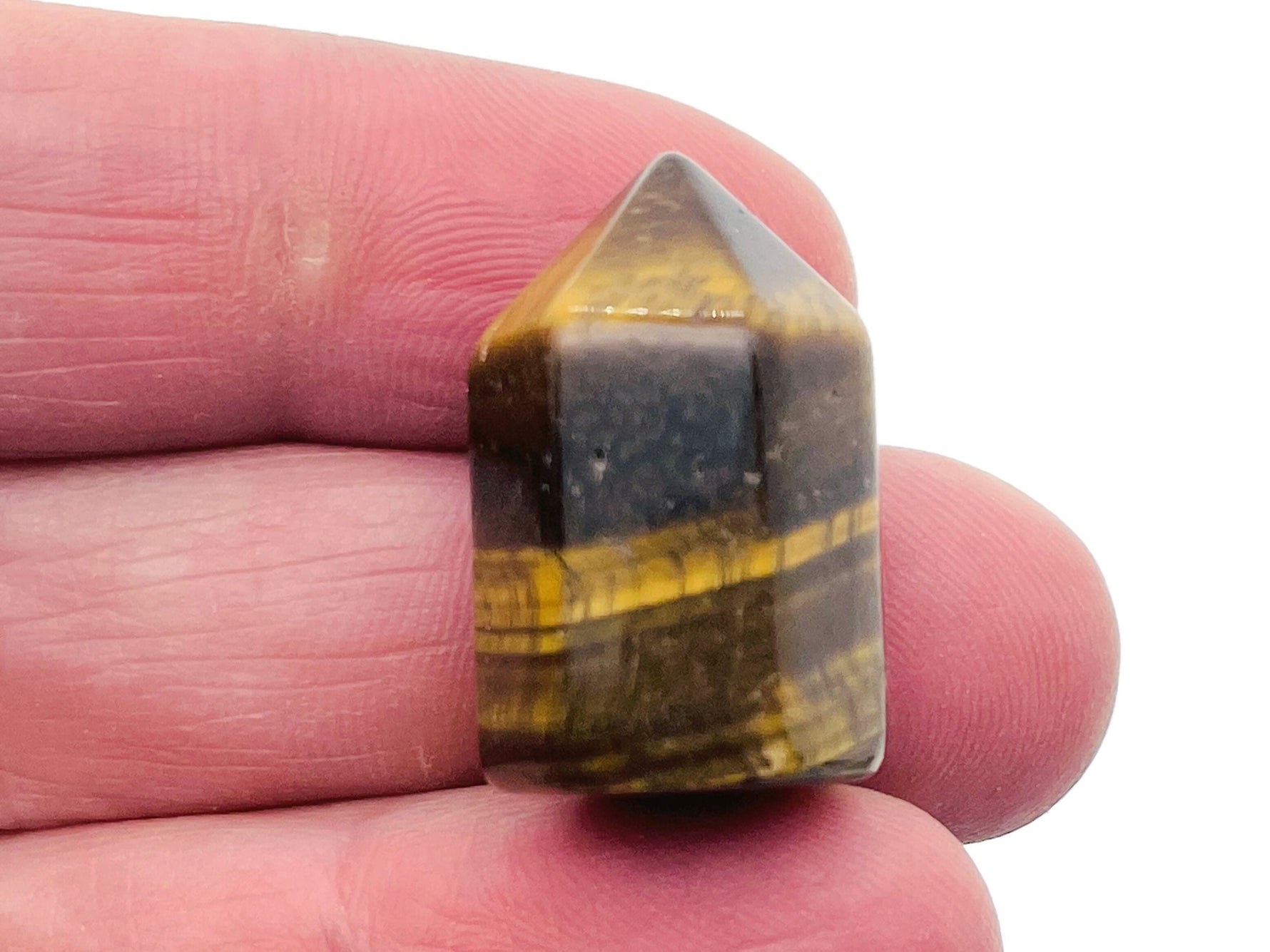 Tiger Eye obelisk tower crystal, 25mm, from GemstoneGO, showing a polished brown and gold striped gemstone with pointed shape.