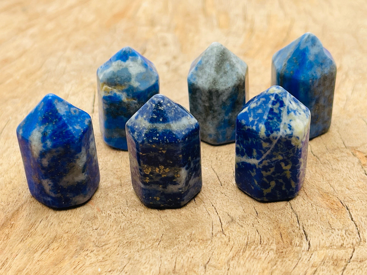 Lapis Lazuli obelisk tower crystal, 25mm, from GemstoneGO, showcasing deep blue stone with gold pyrite flecks and polished finish.