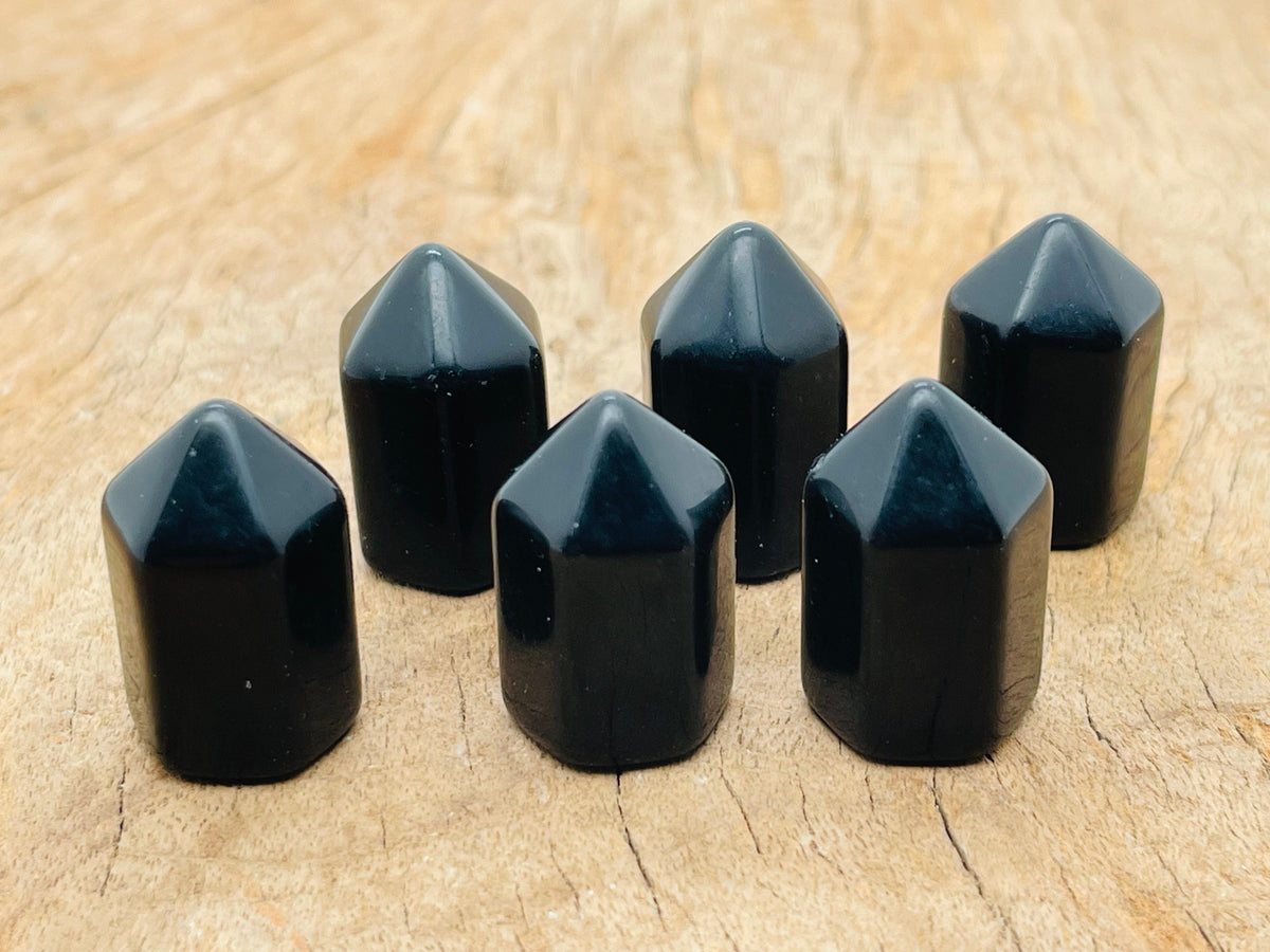 25mm Obsidian obelisk tower crystal from GemstoneGO, showcasing a sleek black polished stone with natural reflective surfaces.