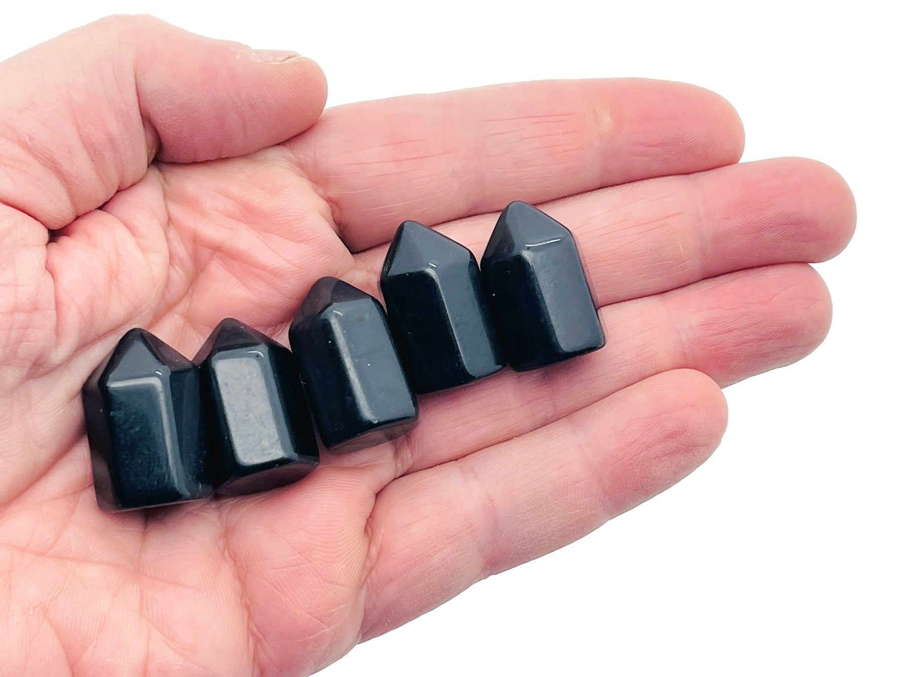 25mm Obsidian Obelisk Tower crystal from GemstoneGO, showcasing a sleek black polished stone with natural stone patterns.