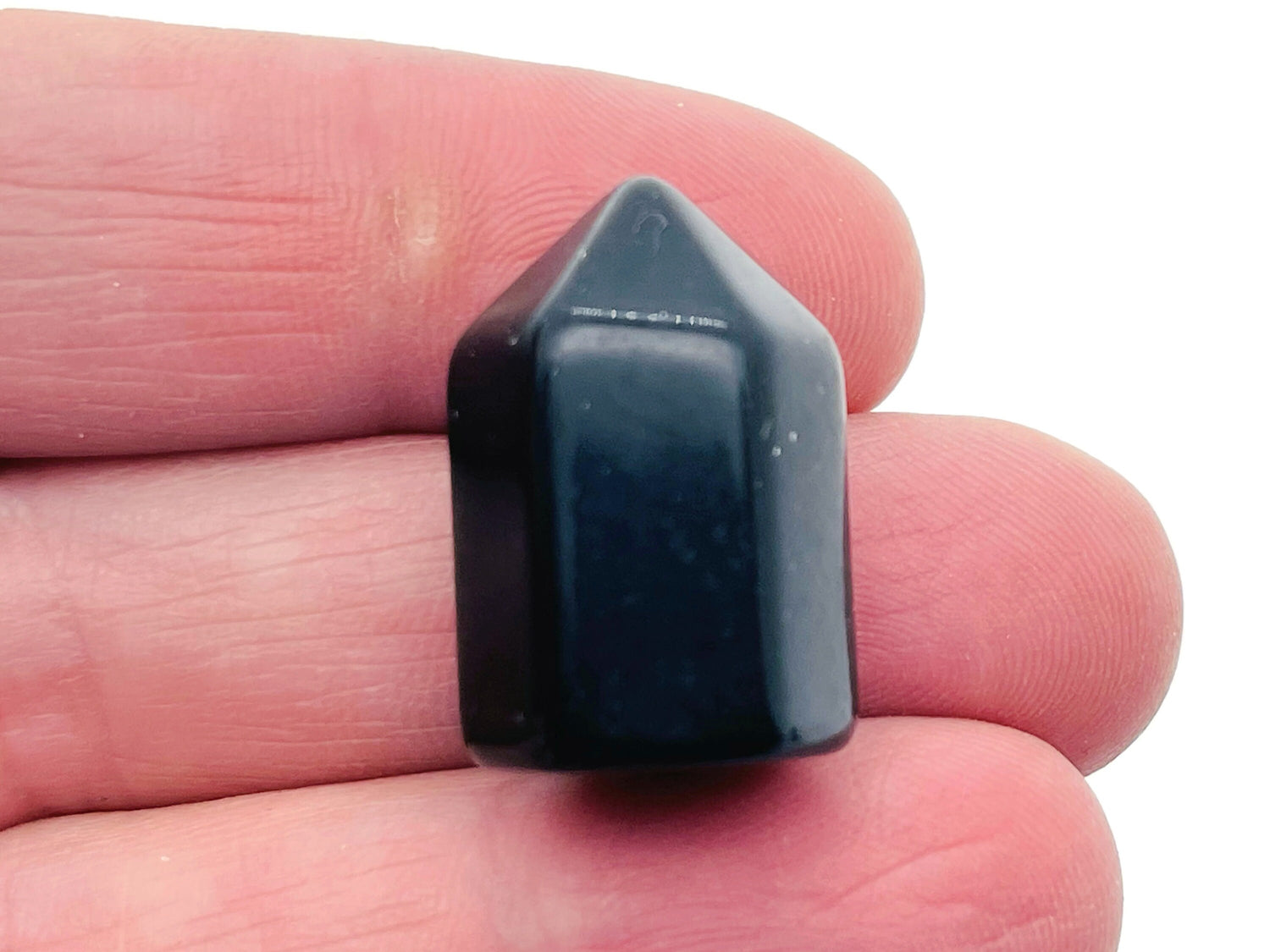 Polished 25mm black obsidian obelisk tower crystal from GemstoneGO, with smooth surface and pointed top.