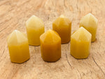 Yellow aventurine obelisk tower crystal, 25mm, from GemstoneGO, showing a polished yellow gemstone with natural stone textures.