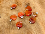 Carnelian heart-shaped pendant with crystals, gemstone healing jewelry, small crystal pendant, featuring vibrant orange-red stone.