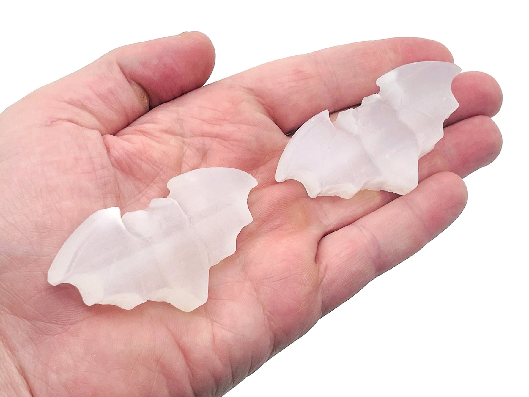Selenite gemstone carving of a bad symbol, showcasing smooth, translucent white stone with detailed craftsmanship from GemstoneGO.