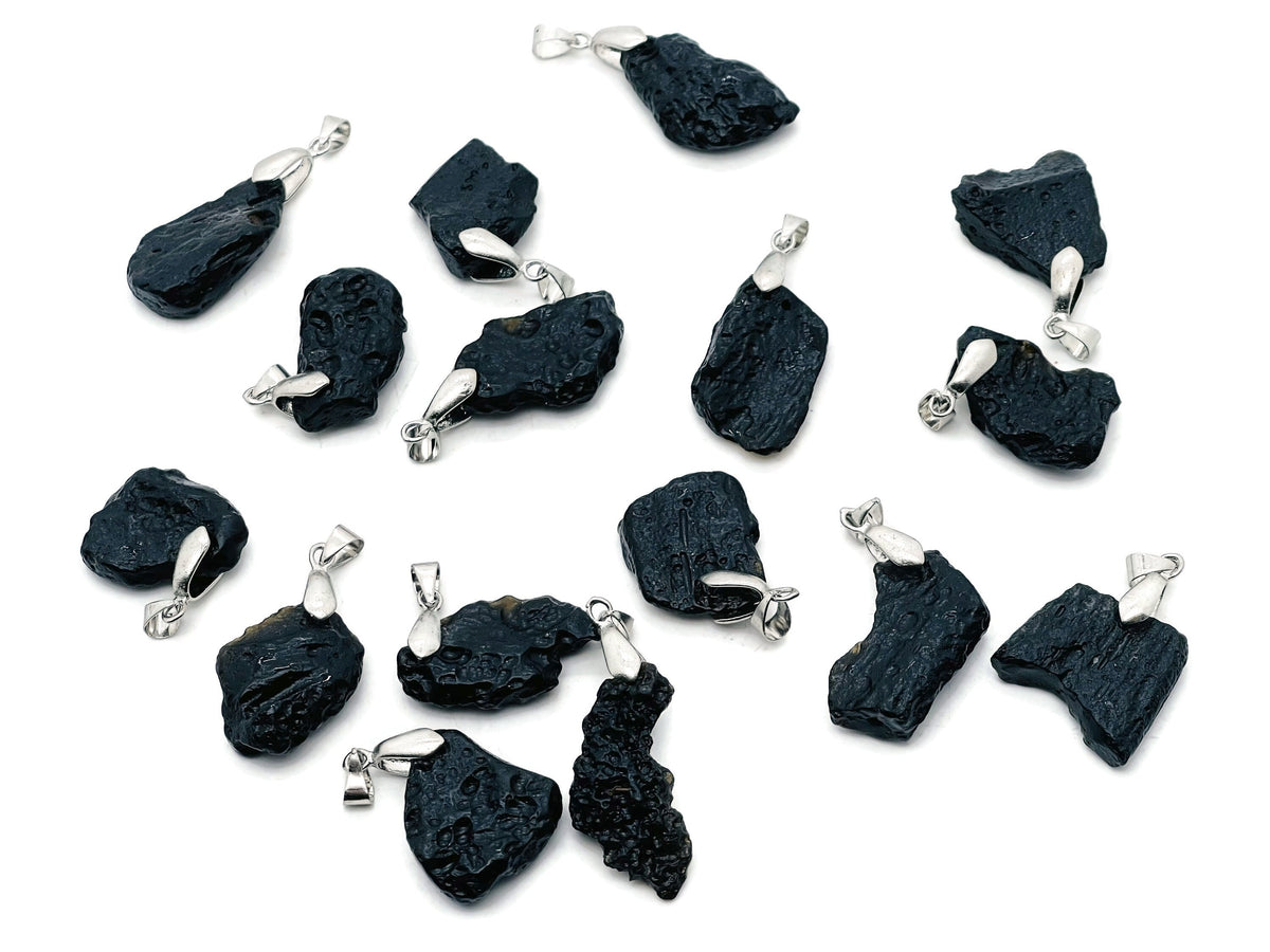 Tektite pendant featuring Tibetan Tektike meteorite and gemstone, showcasing a polished, dark mineral pendant on a chain.