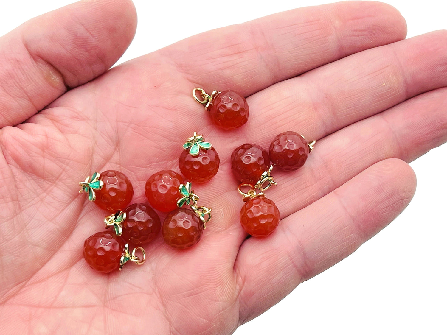 Carnelian crystal pendant from GemstoneGO, shown with a smooth, oval-shaped orange gemstone for jewelry making.
