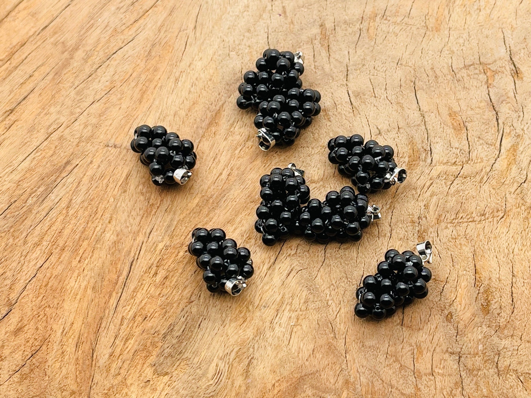 Obsidian Grape Crystal Pendant by GemstoneGO featuring a detailed crystal grape design on a silver chain.