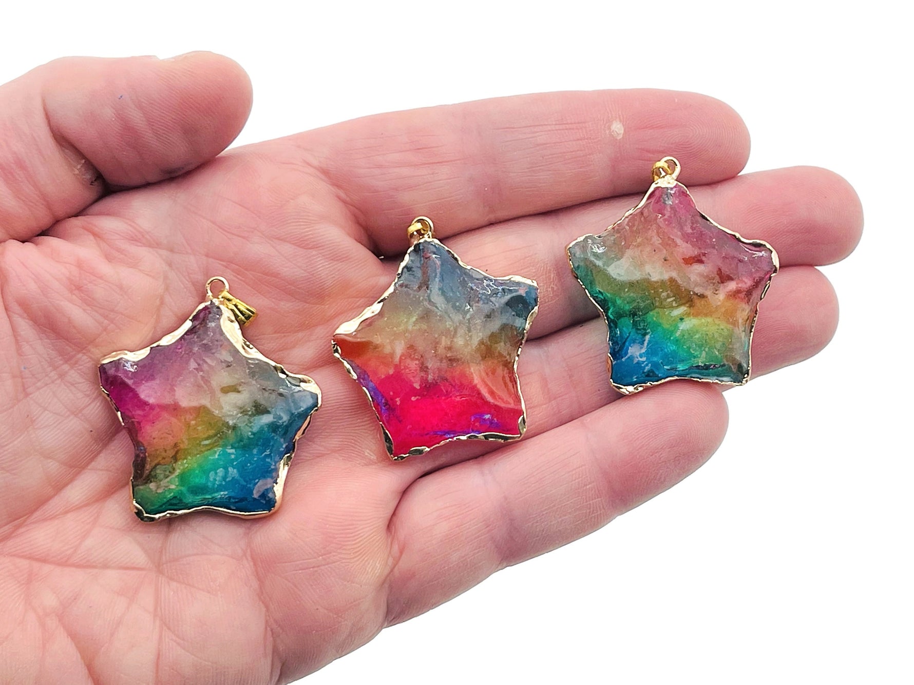 Rainbow Aura Star Crystal Pendant from GemstoneGO featuring pink, yellow, and blue hues, displayed as a loose crystal gemstone.