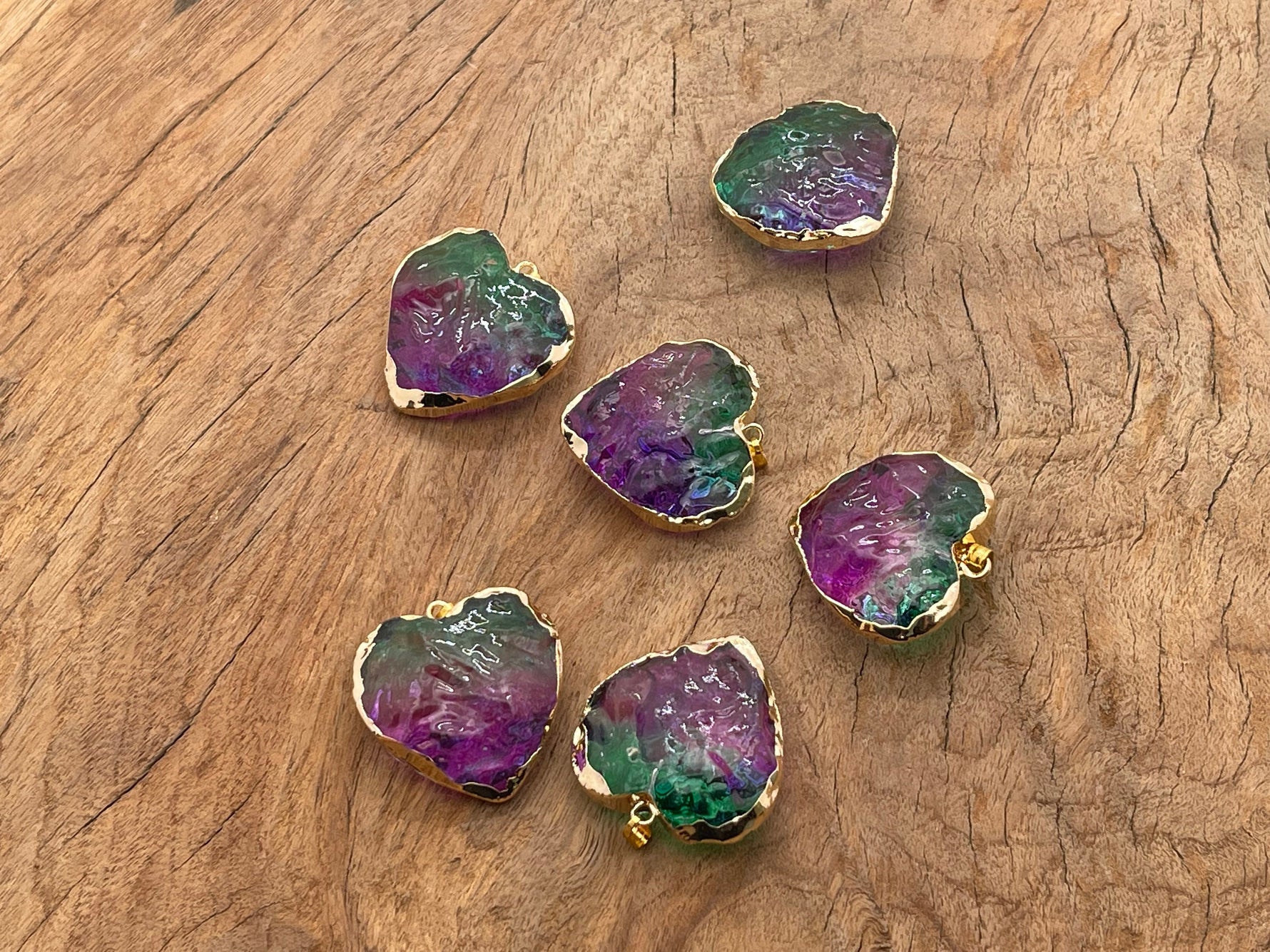 Green and purple rainbow aura heart crystal pendant from GemstoneGO, showcasing a loose, vibrant gemstone with iridescent shine.