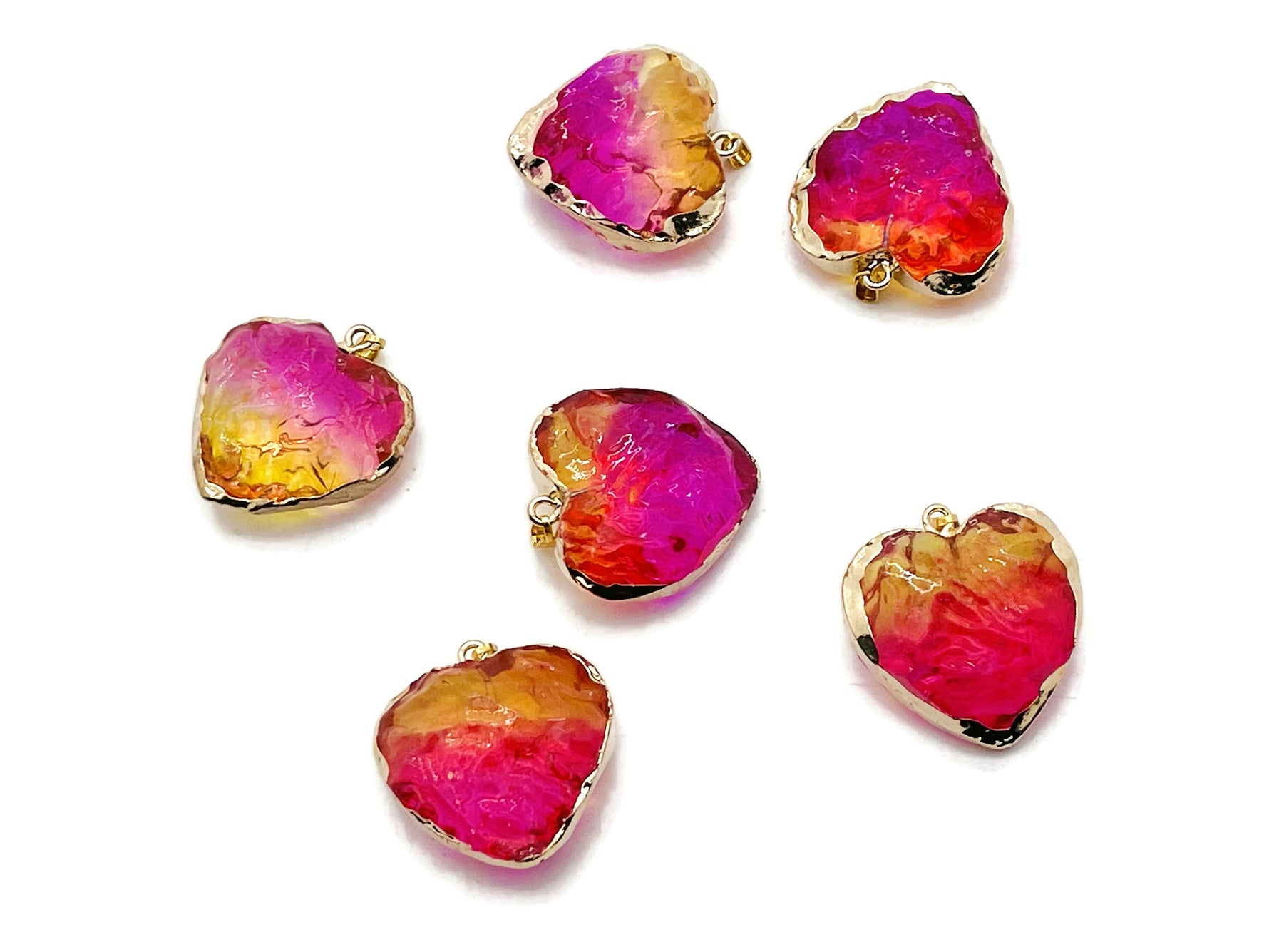 Pink and yellow rainbow aura heart crystal pendant from GemstoneGO, showcasing a vibrant, loose gemstone with iridescent rainbow hues.