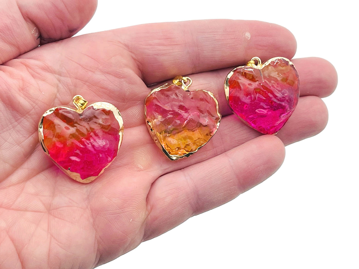 Pink and yellow rainbow aura heart crystal pendant from GemstoneGO featuring a loose crystal with vibrant, iridescent colors.