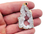 White agate geode druzy slice crystal pendant with natural sparkling crystals, featuring a polished edge and a silver bail attachment.