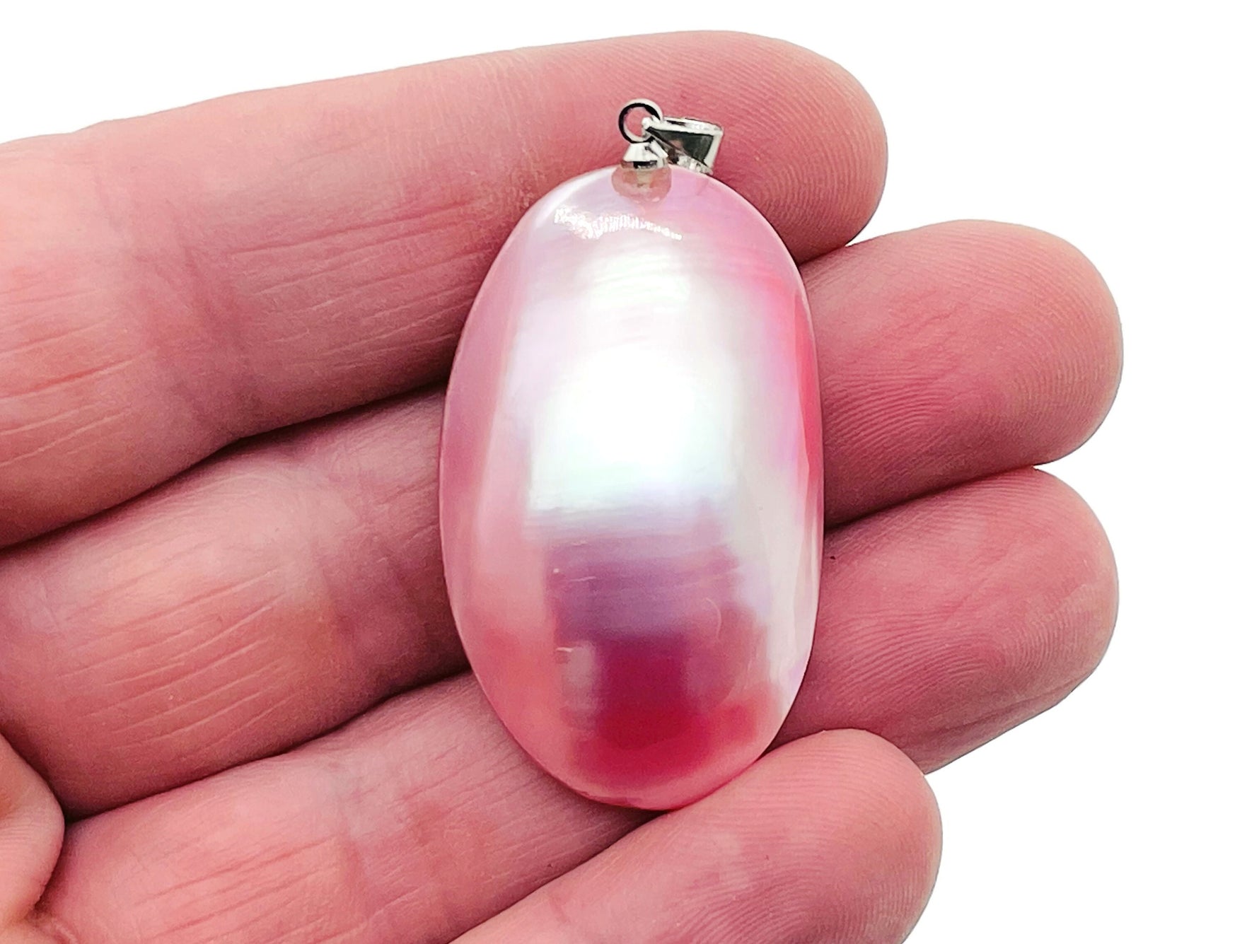 Pink natural pearl pendant from GemstoneGO, showcasing a delicate pearl with a jewelry-making setting on a neutral background.