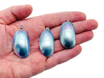 Blue natural pearl pendant from GemstoneGO, showcasing a lustrous pearl with a silver setting on a jewelry-making display.