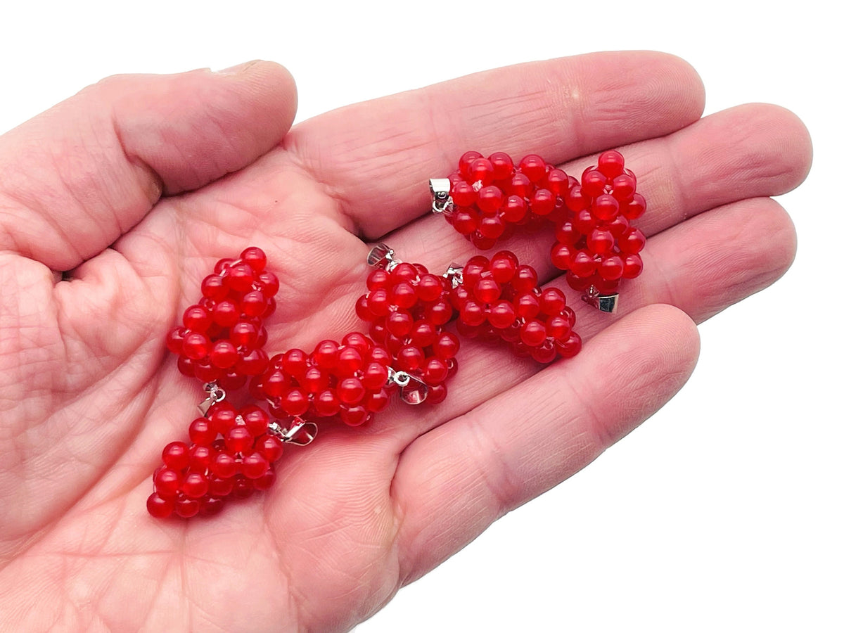 Carnelian grape-shaped crystal pendant by GemstoneGO featuring vibrant orange-red gemstone and intricate grape cluster design.