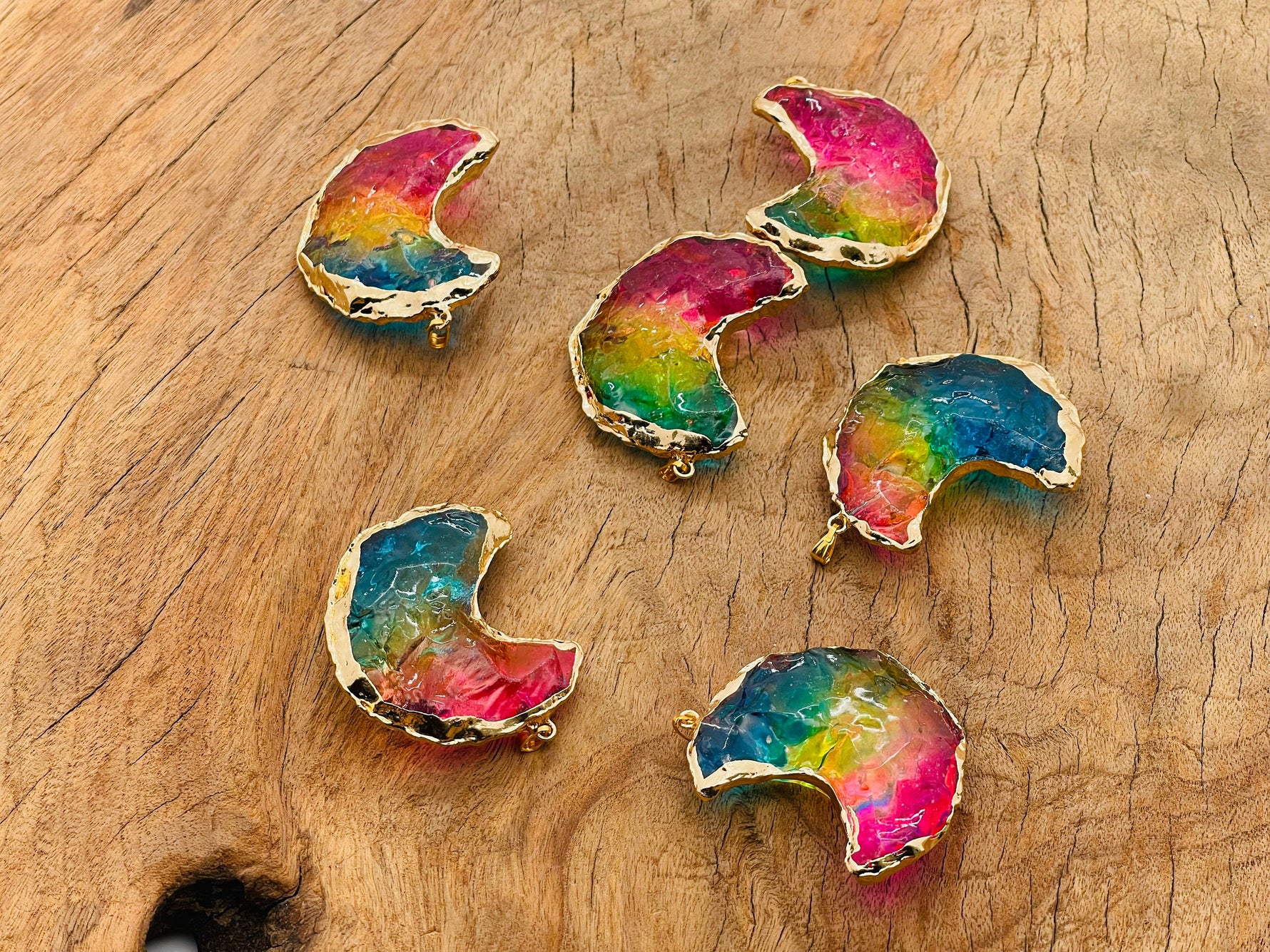 Rainbow aura moon crystal pendant featuring blue, yellow, and pink hues, showcasing a loose gemstone with a shimmering finish.