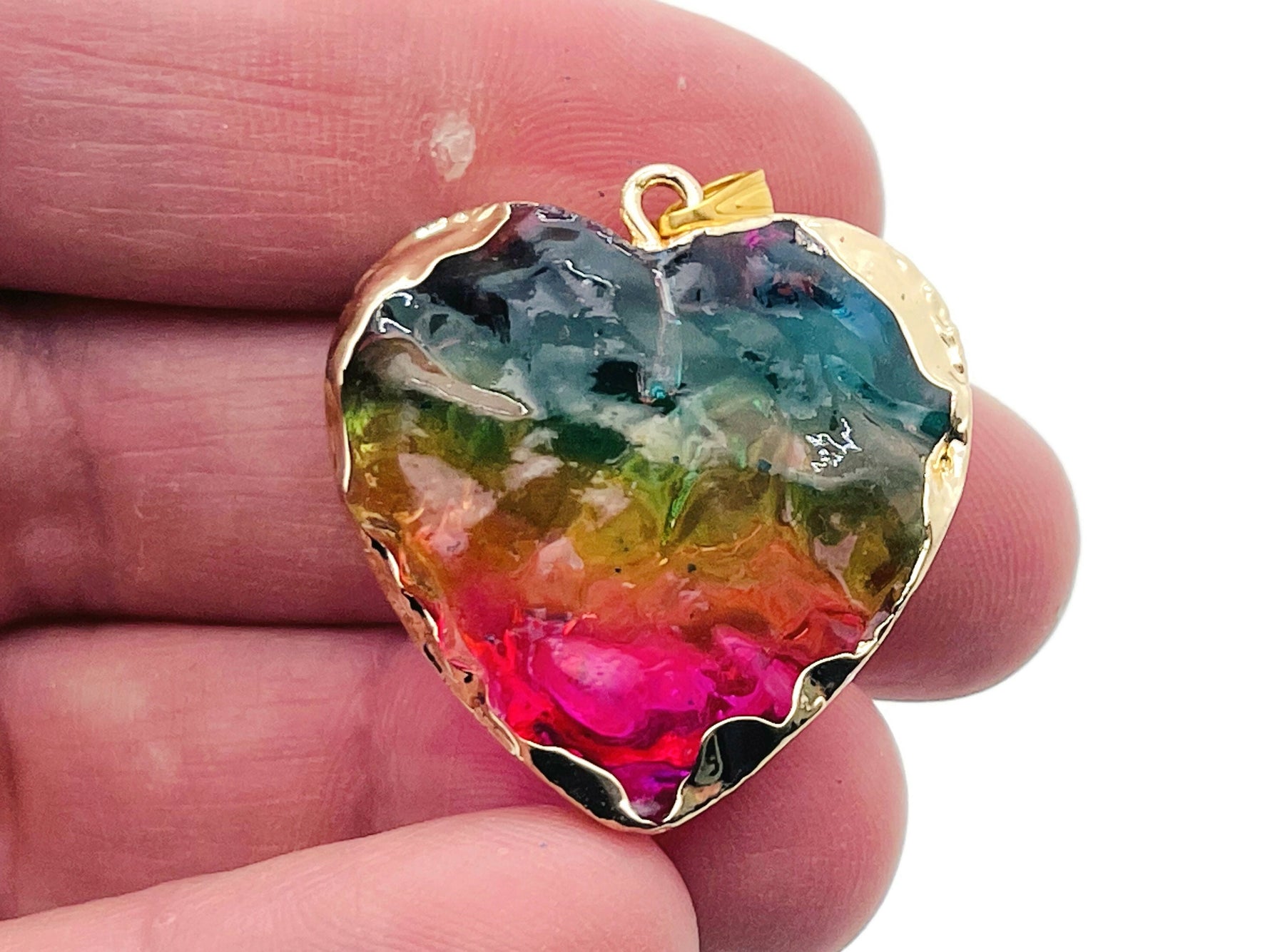 Pink, yellow, and blue rainbow aura heart crystal pendant by GemstoneGO, showcasing a vibrant, loose gemstone with a shimmering rainbow finish.