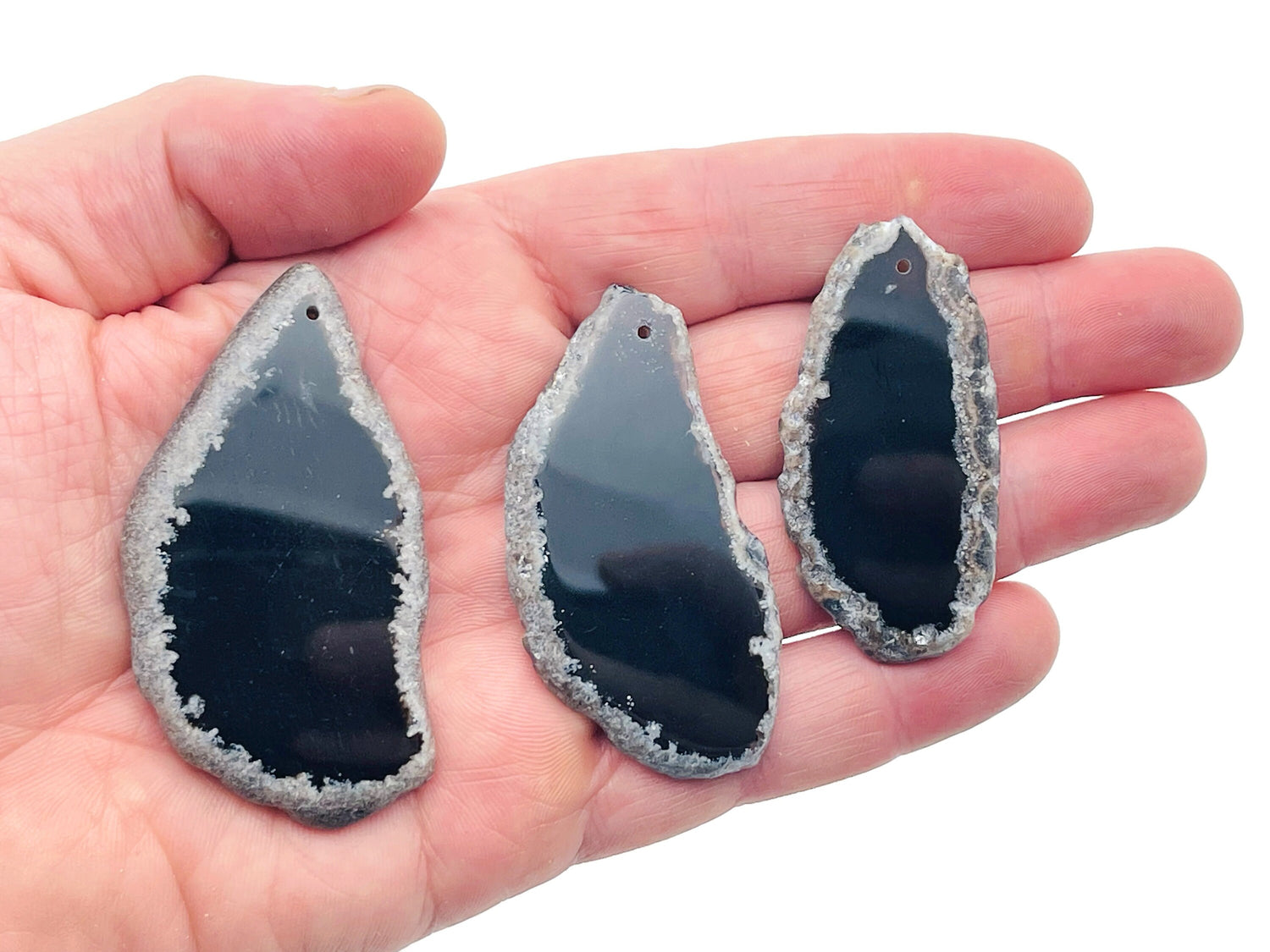 Black Agate Slice drilled gemstone pendant with natural hole, showcasing polished black agate with layered, banded patterns for jewelry.