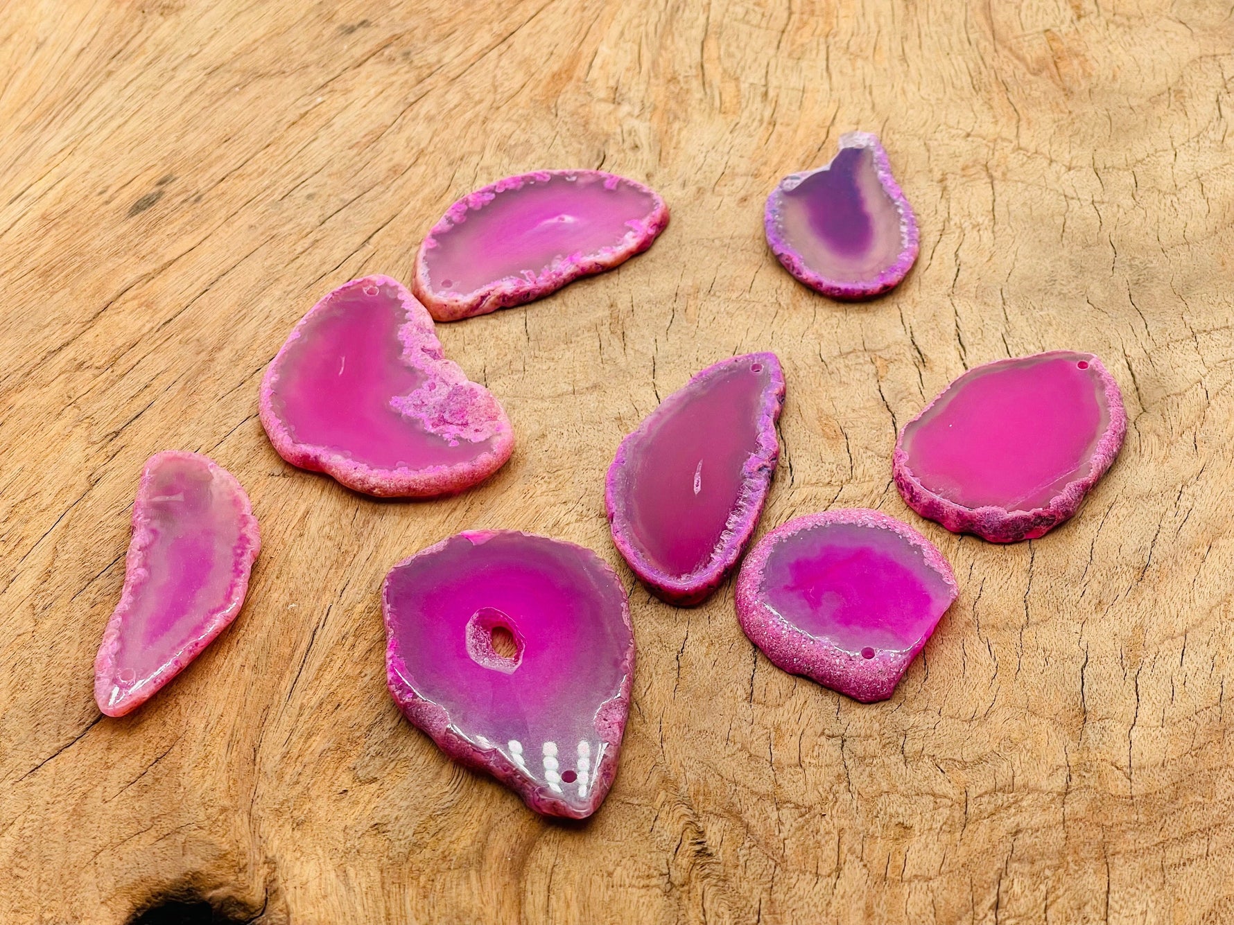 Pink agate slice drilled pendant featuring a natural geode with polished pink stone and a drilled hole for jewelry making.