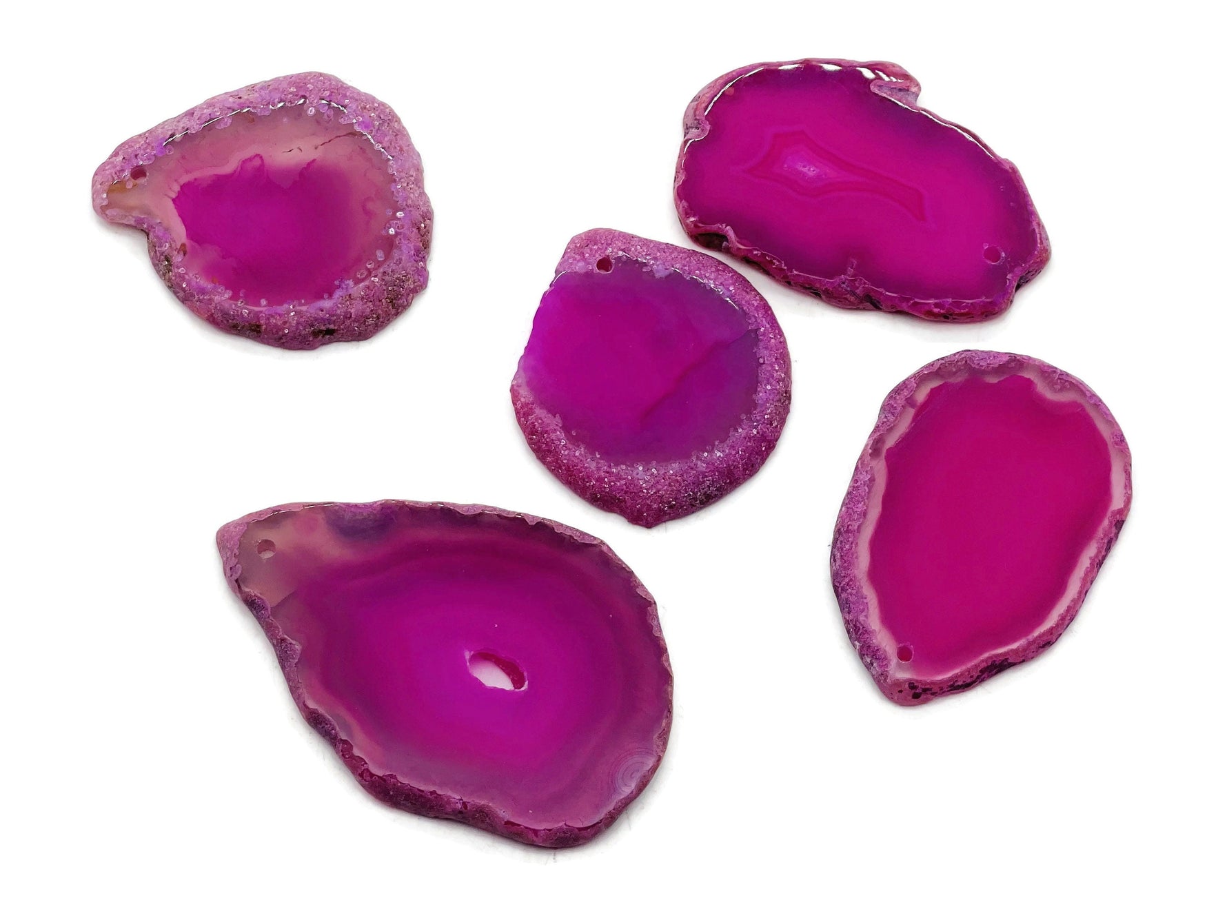 Pink agate slice drilled pendant with natural gemstone texture and hole, showcasing a vibrant pink geode crystal from GemstoneGO.