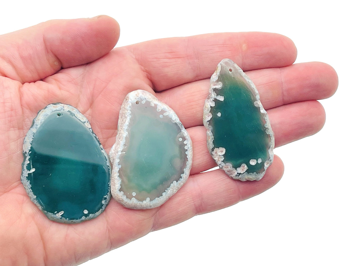 Green agate slice drilled gemstone pendant for jewelry making, showcasing a vibrant, polished geode crystal with natural banding.