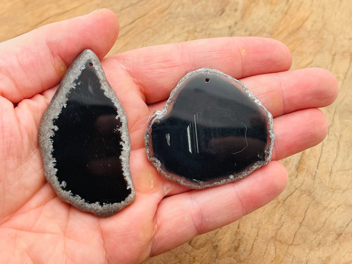 Black Agate Slice drilled pendant showcasing a smooth, polished black agate geode with a hole for jewelry making.