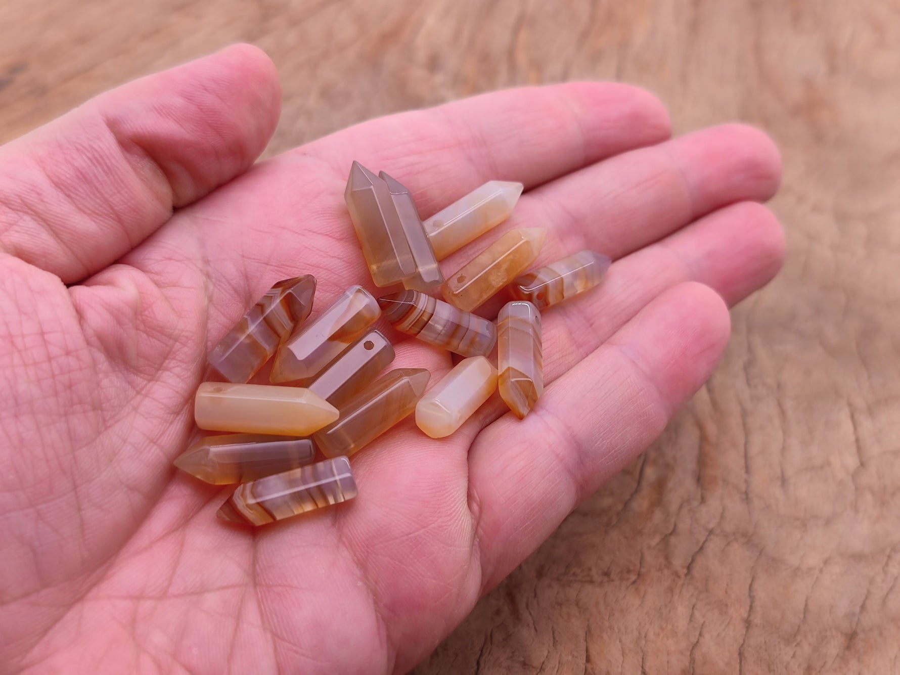 Carnelian point hole crystal pendant by GemstoneGO showing a drilled orange carnelian crystal point with natural textures.