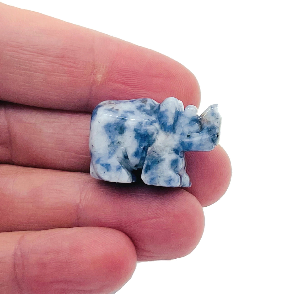 Handmade 30mm crystal gemstone rhino animal figure by GemstoneGO, carved with detailed features on a natural stone surface.